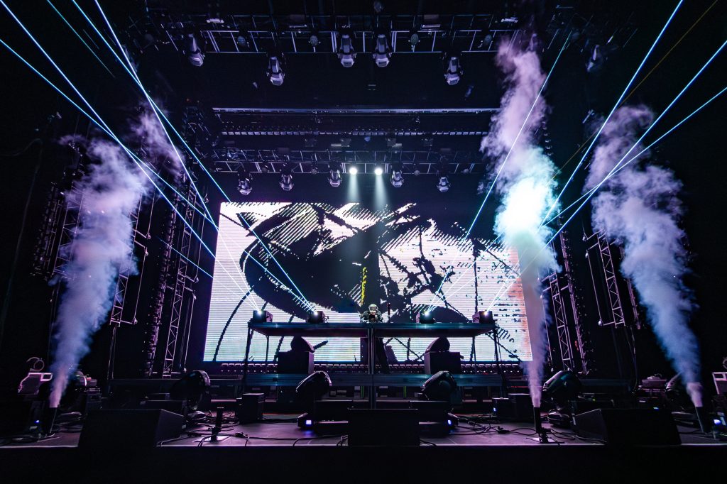 Juelz takes the stage with CO2 cannons and lasers launching in front of industrial visuals in the back.