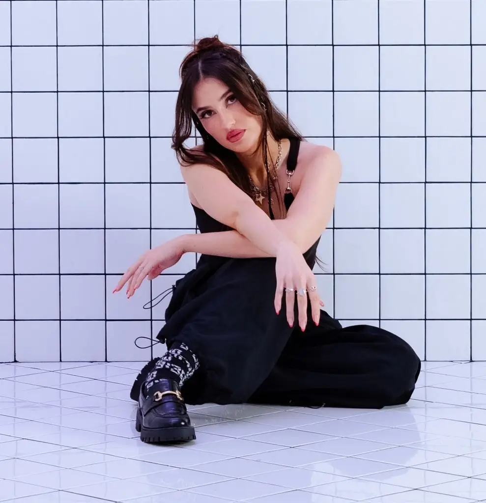 woman posing in front of a tiled wall