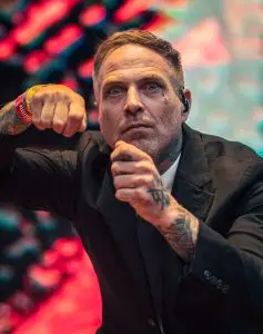 A singer poses while wearing a suit onstage